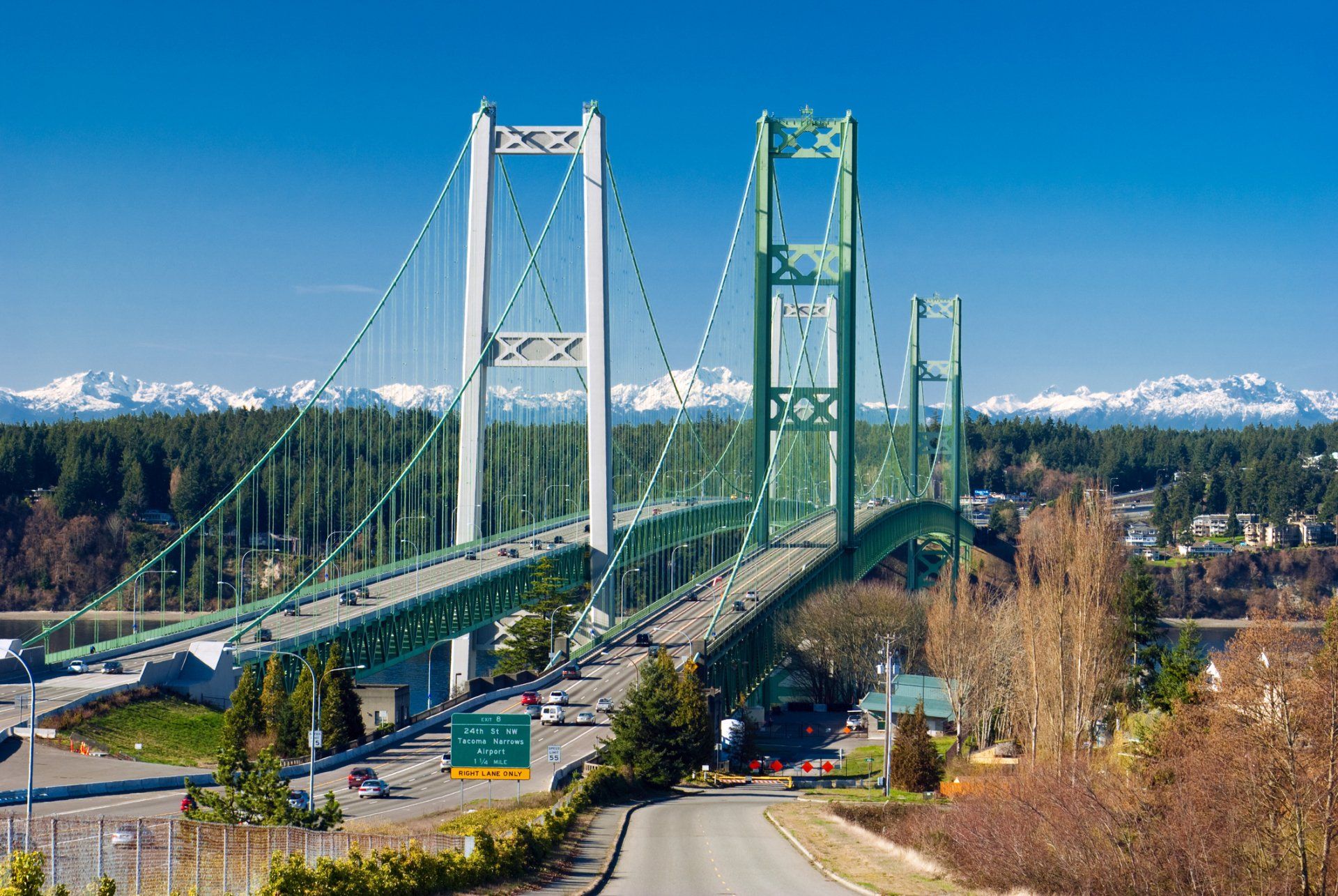 A bridge over a body of water with mountains in the background