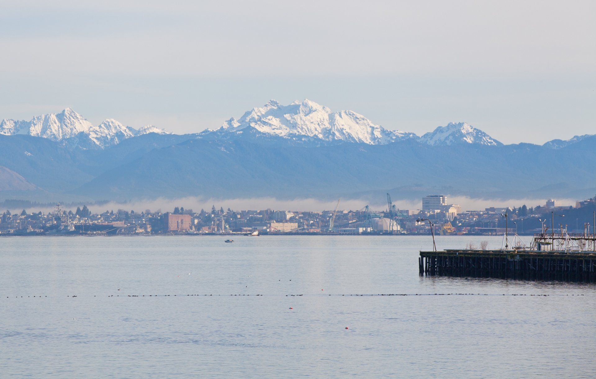 A body of water with mountains in the background and a dock in the foreground