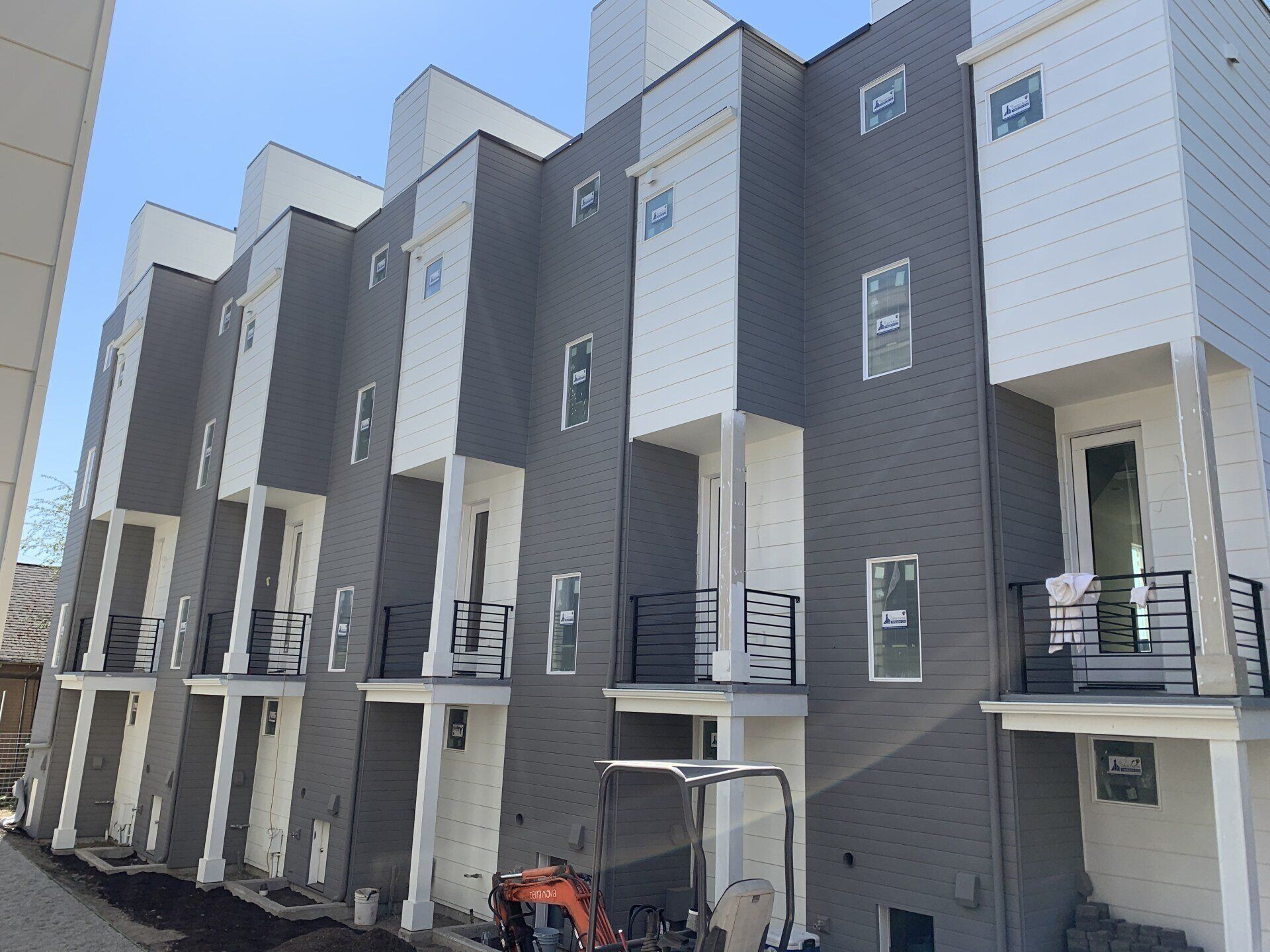 A row of gray and white apartment buildings with balconies