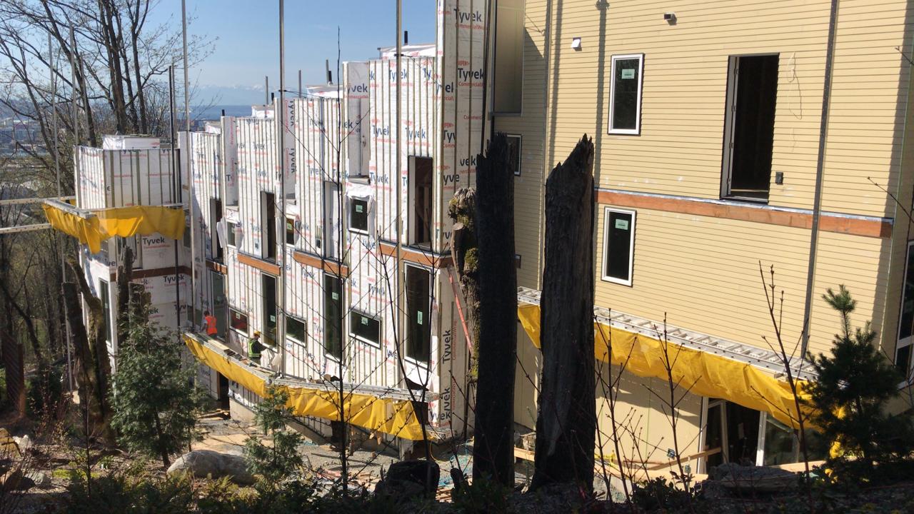 A large building is being built on top of a hill.