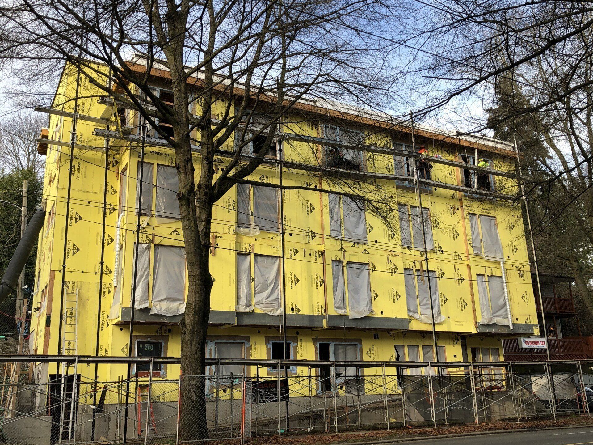 A large yellow building with scaffolding around it is being built.
