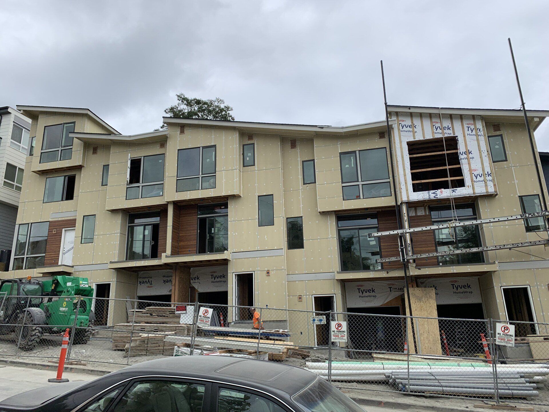 A building under construction with a car parked in front of it.