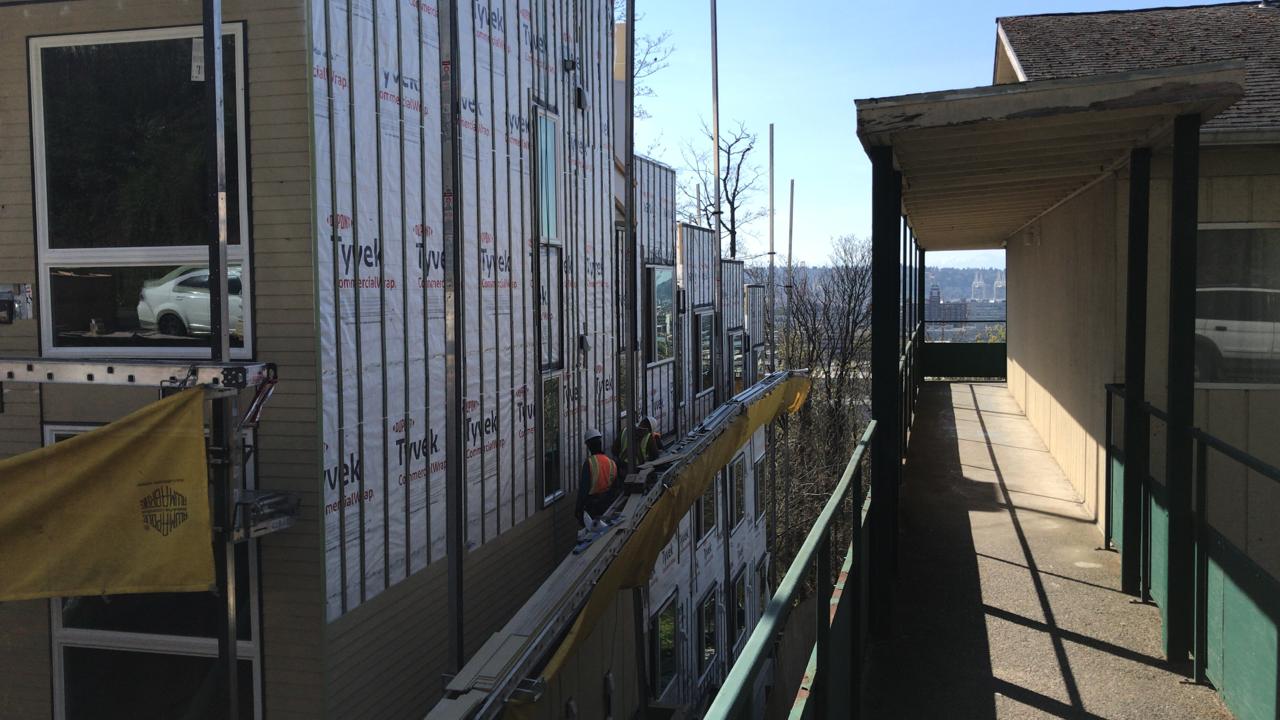 A man is working on the side of a building.