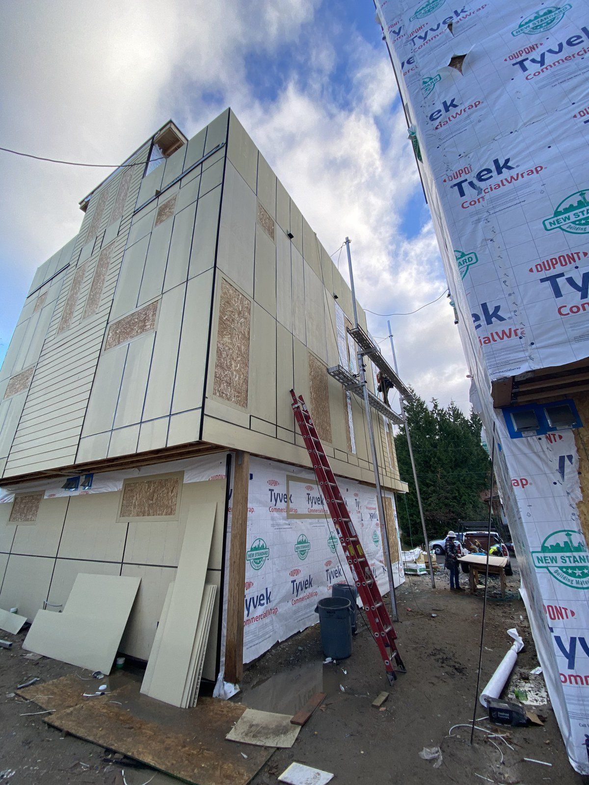 A large building is being built with a ladder in front of it.