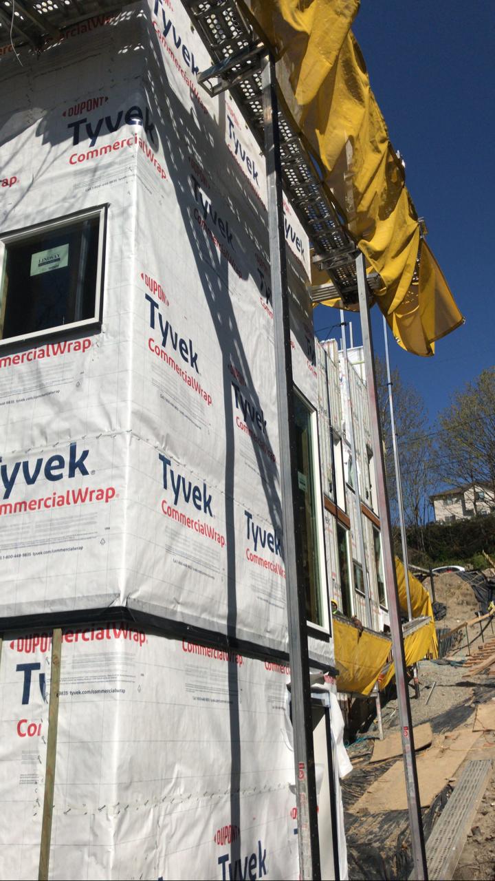 A building is being built on a hill and is covered in styrofoam.