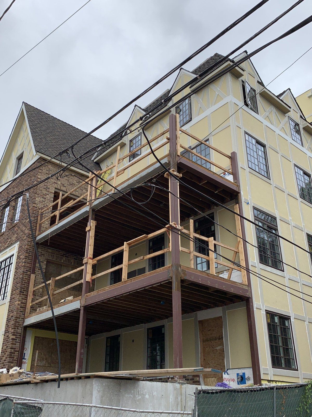A large building under construction with a wooden balcony.