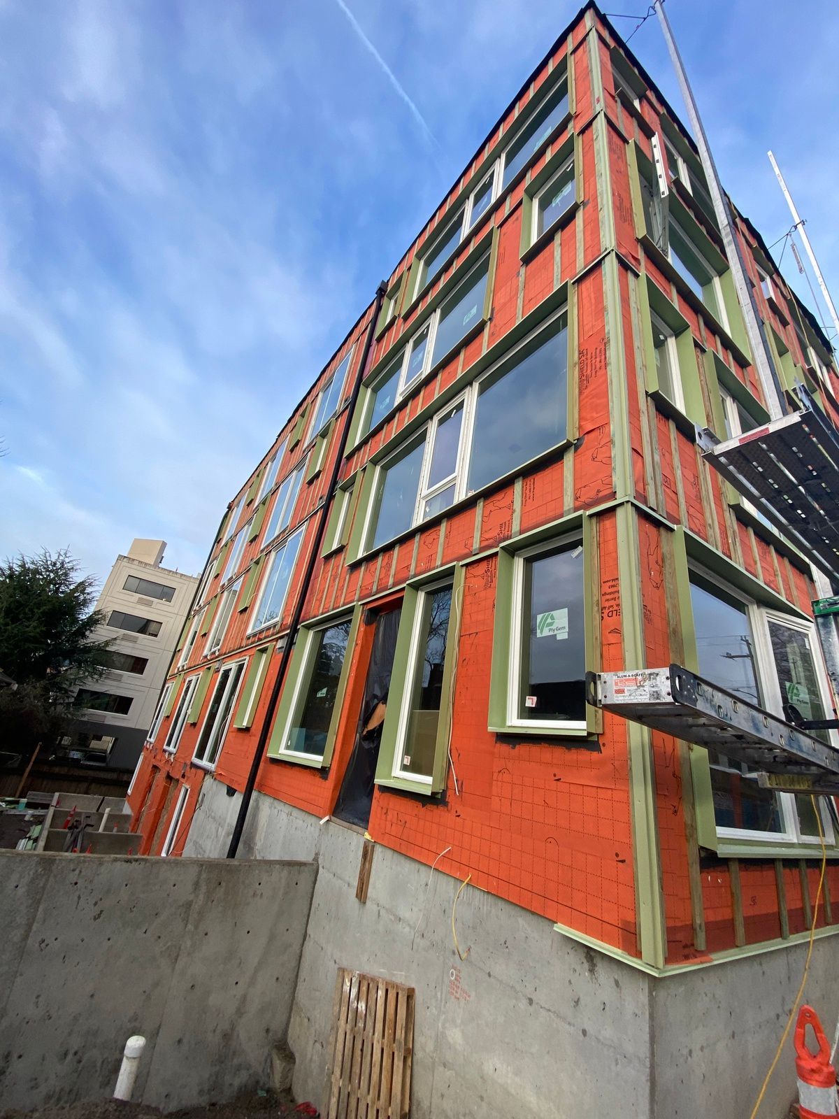 A large orange building with a lot of windows under construction