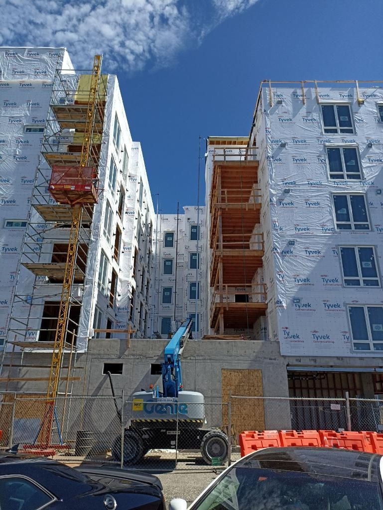 A building under construction with a blue crane in front of it