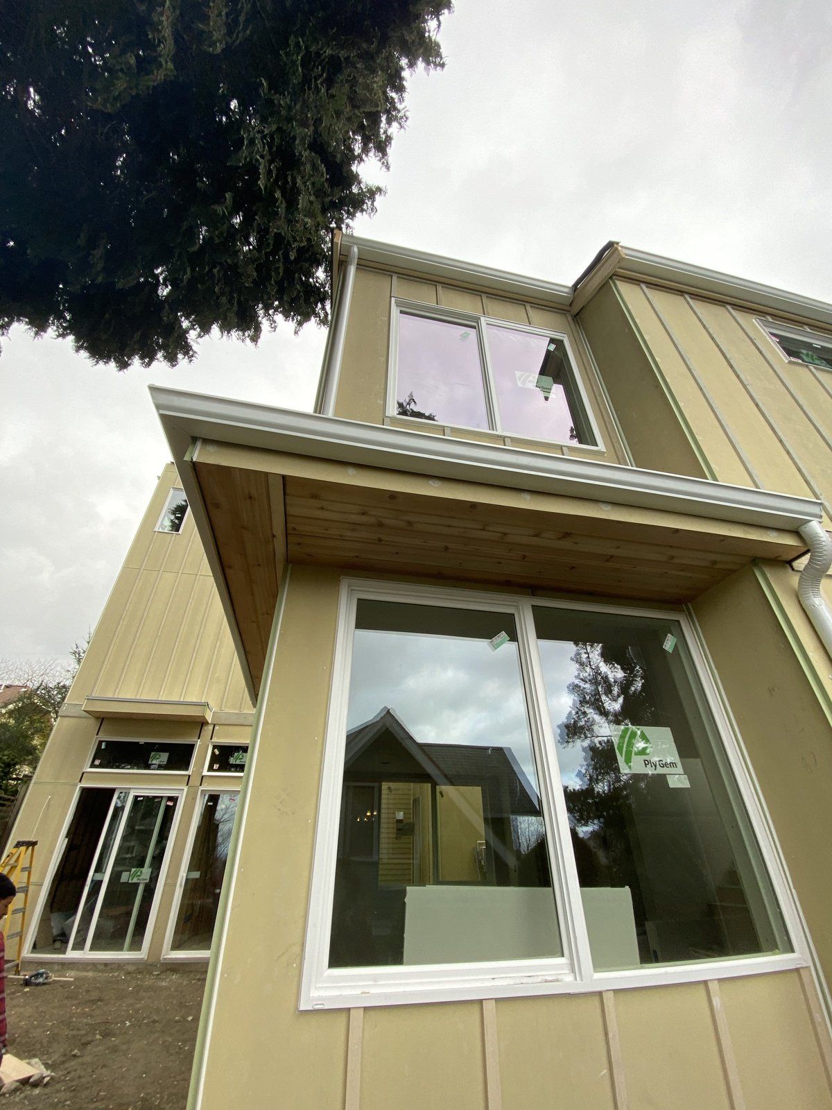 A house with a lot of windows and a tree in the background.