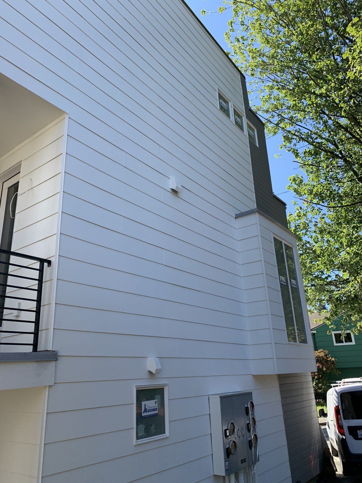 A white house with a van parked in front of it