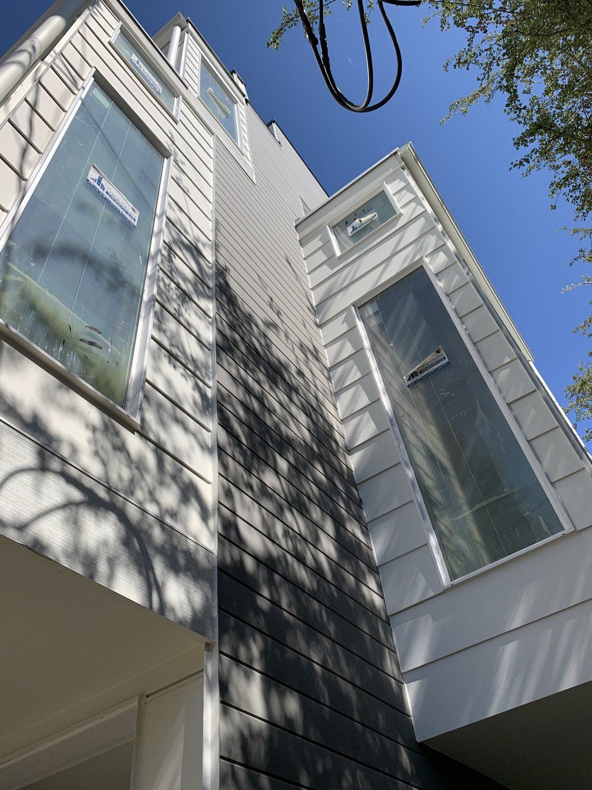 Looking up at a white house with a blue sky in the background.
