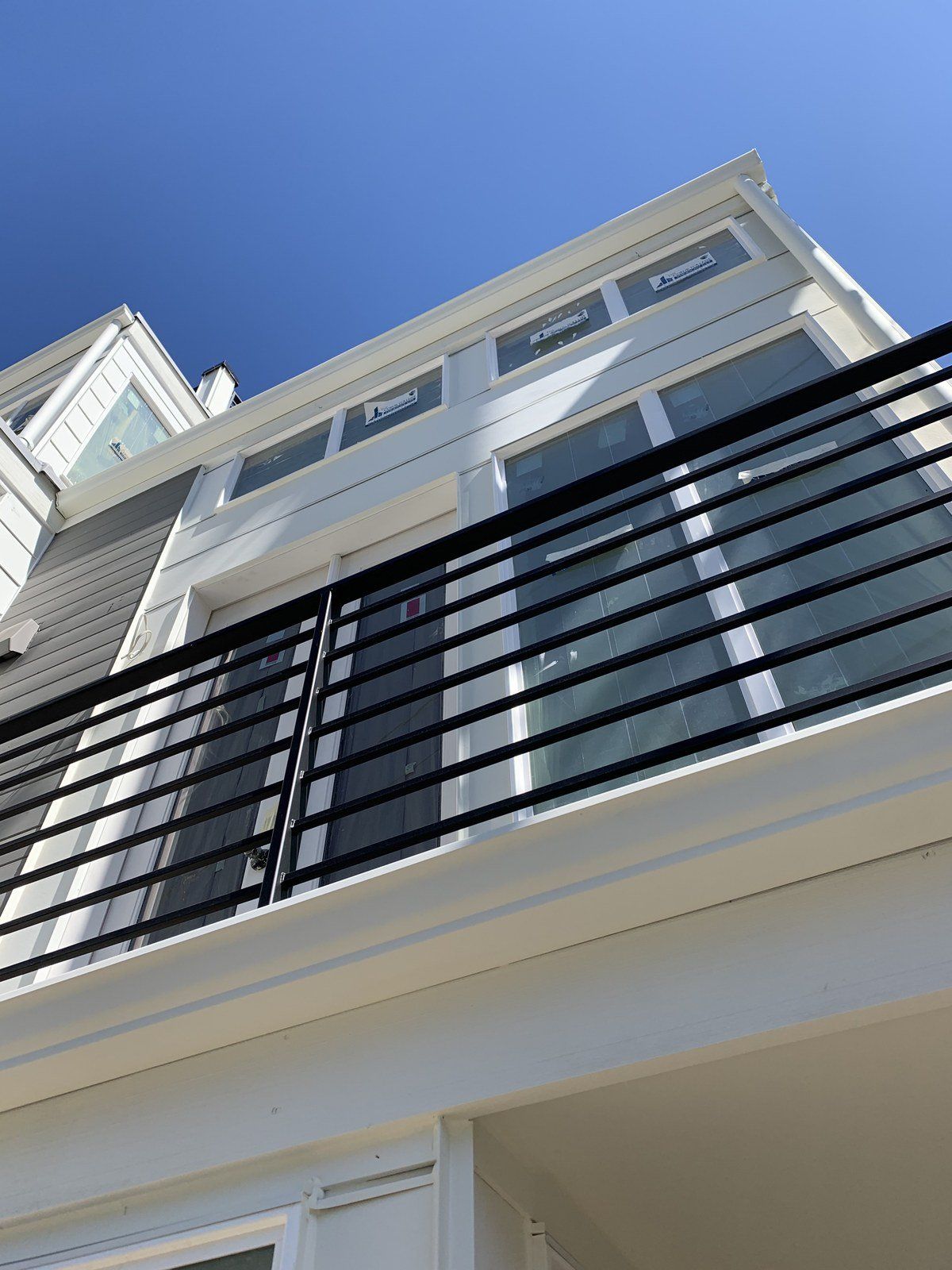A balcony on the side of a building with a blue sky in the background.