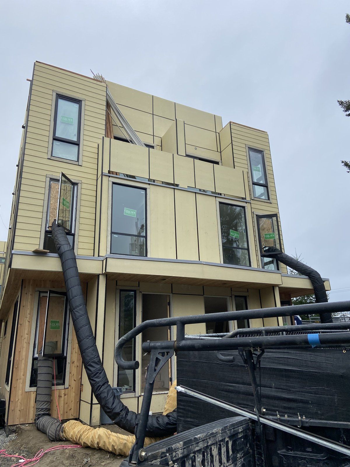 A large building under construction with a truck parked in front of it.