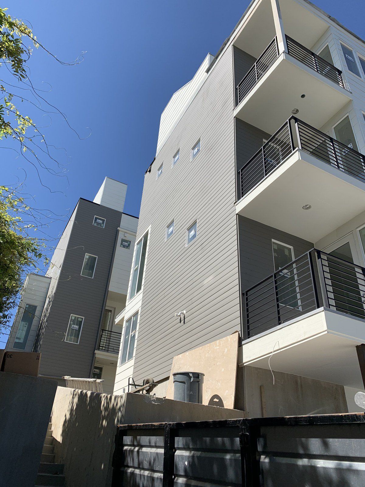 A large apartment building with balconies and a blue sky in the background.
