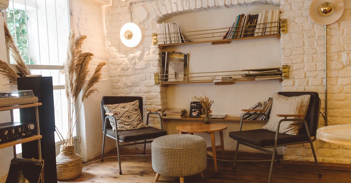 A living room with chairs , a table , and a bookshelf.