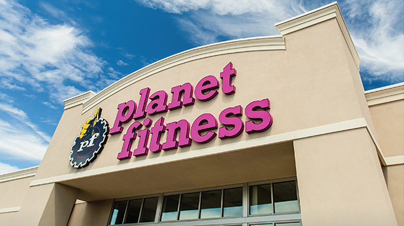 The front of a planet fitness gym with a blue sky in the background.