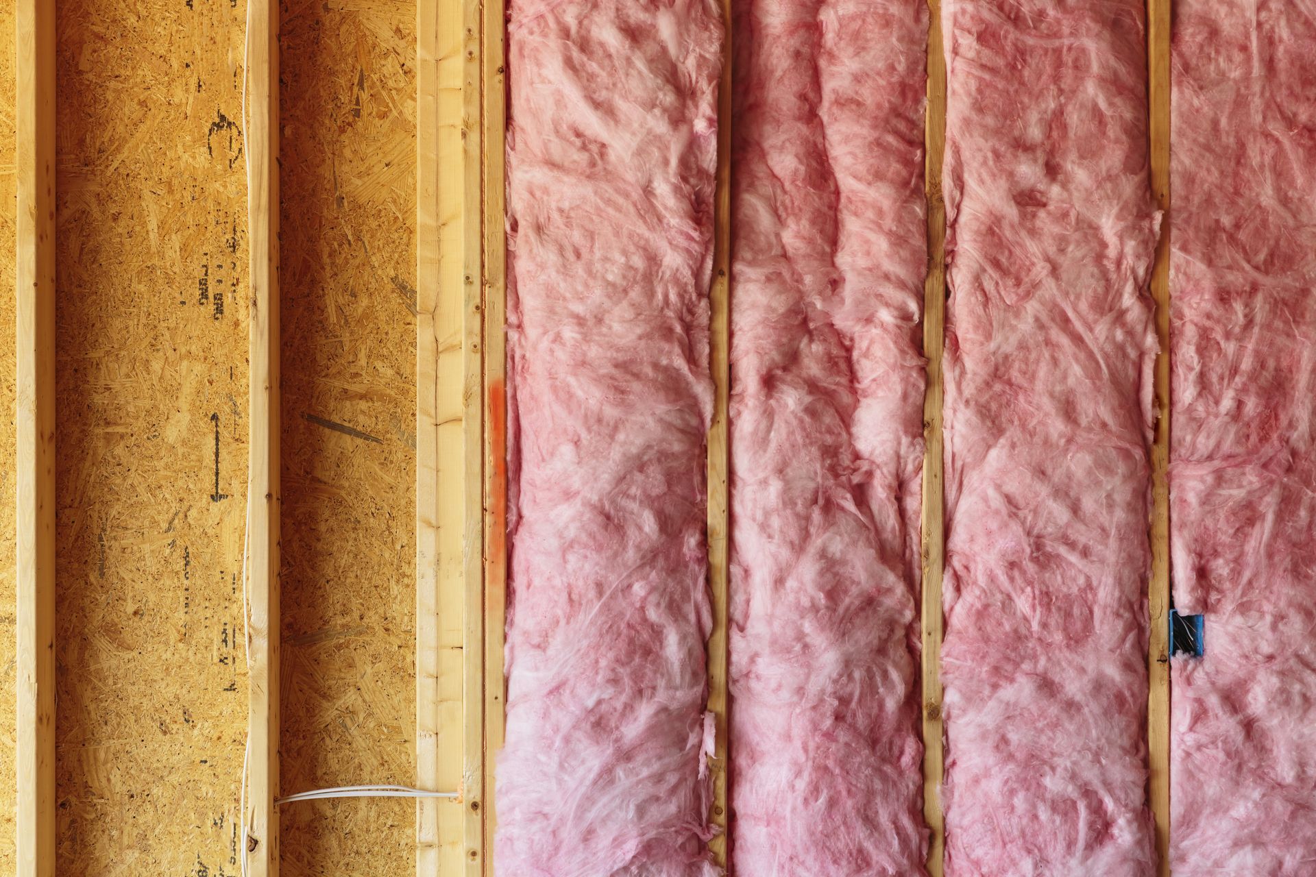A close up of a wall with pink insulation on it.