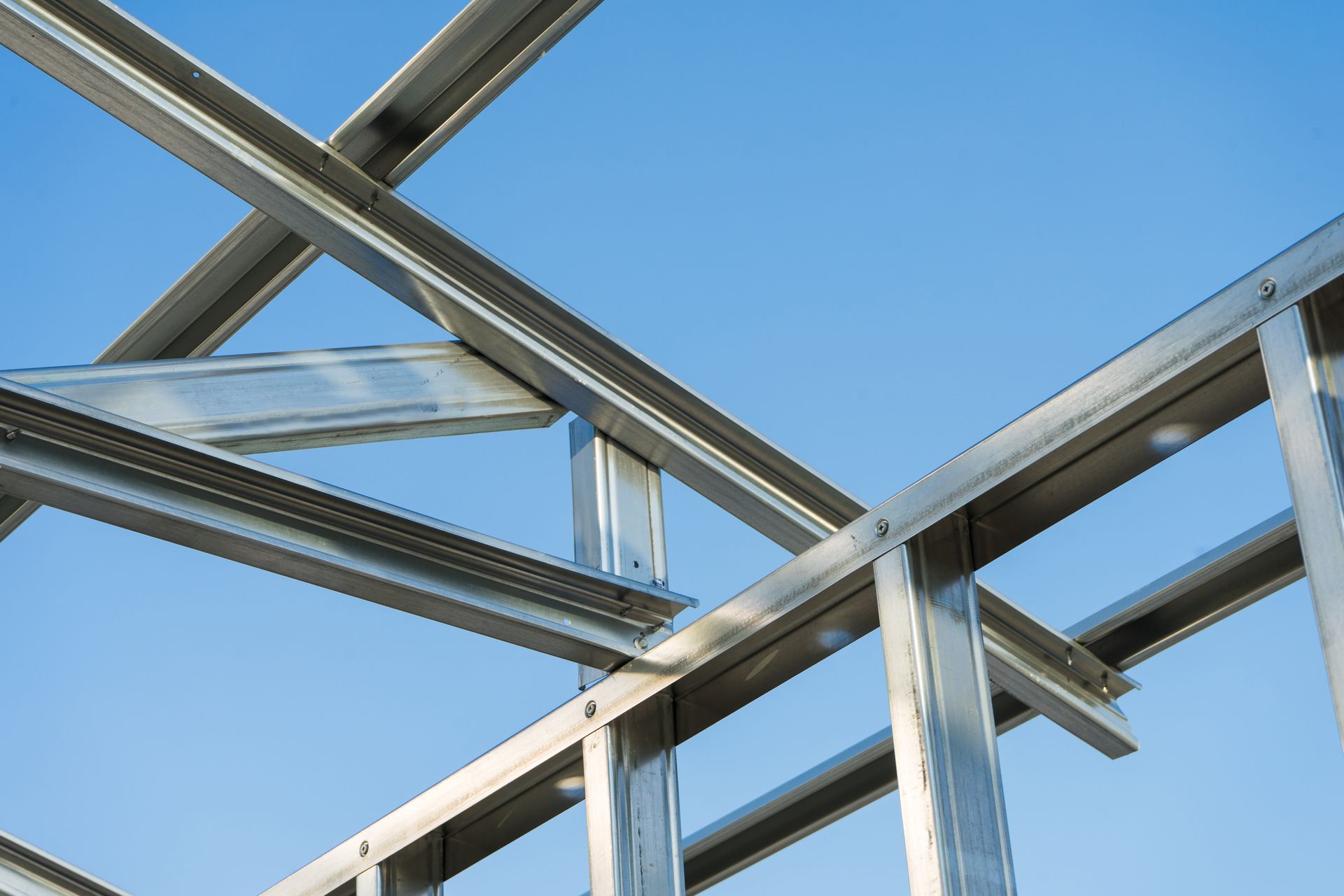 A close up of a metal structure with a blue sky in the background.
