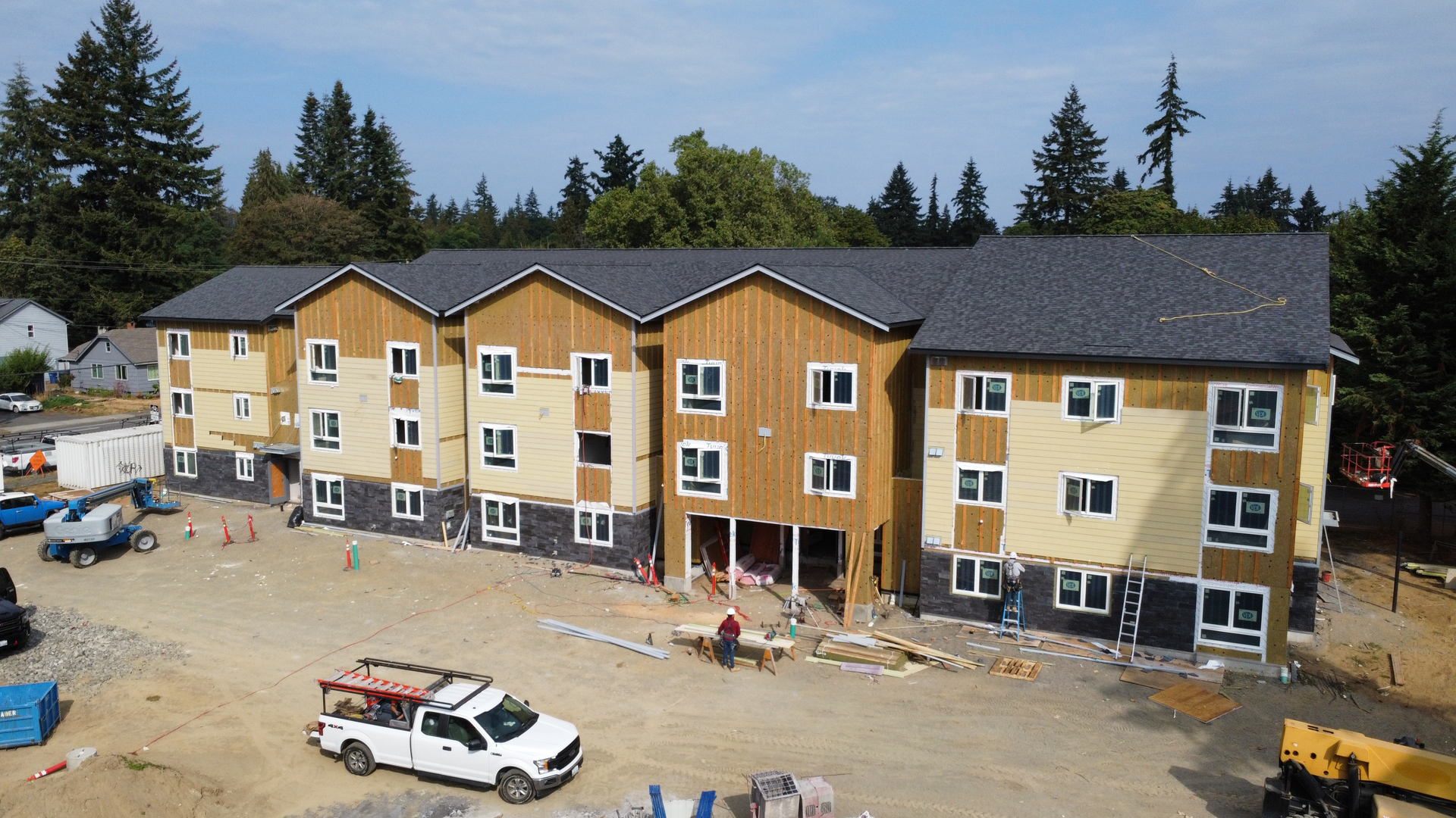 An aerial view of a building under construction with a white truck parked in front of it.