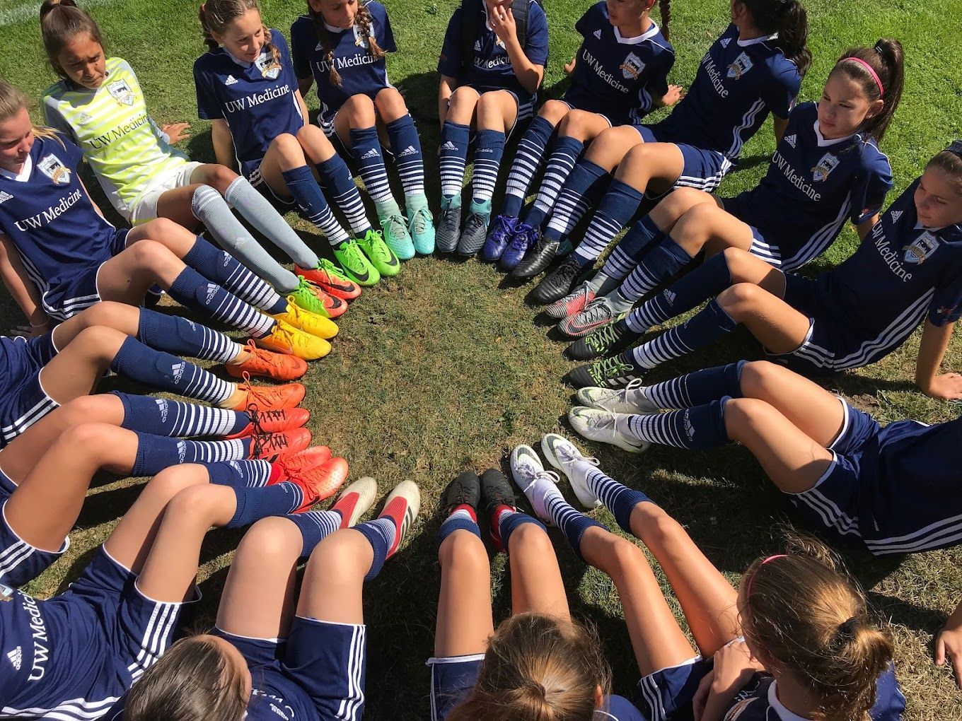 A group of girls are sitting in a circle with their legs crossed