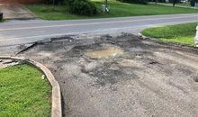 There is a puddle of water on the side of the road.