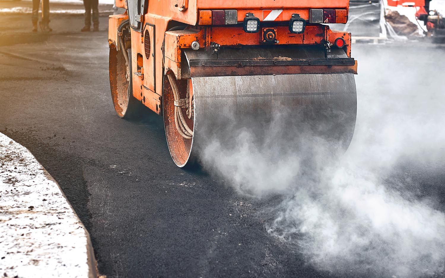 A roller is rolling asphalt on a road.
