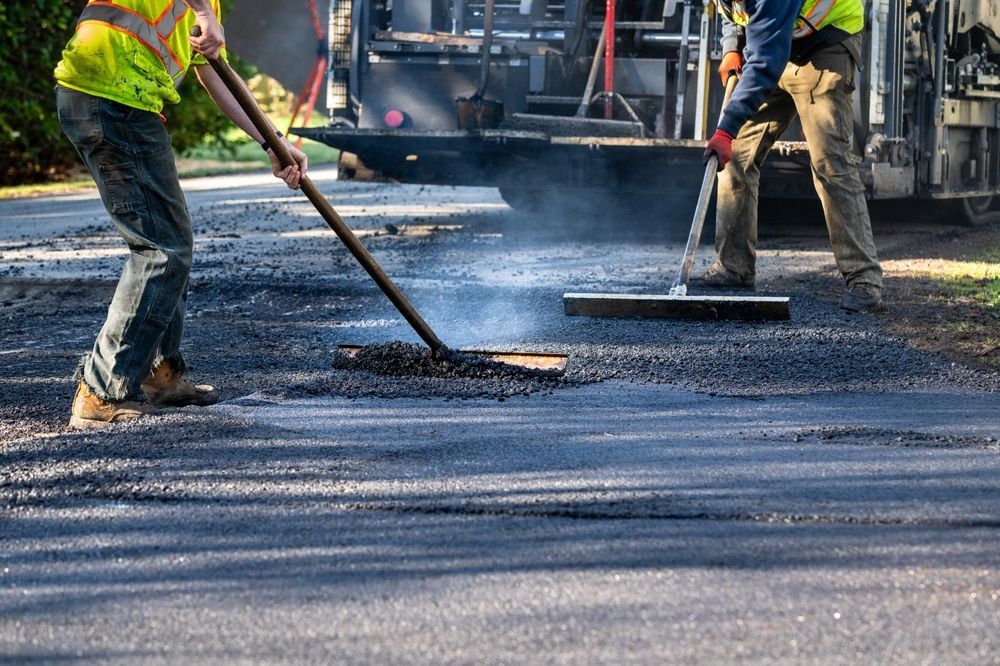 A couple of men are working on a road.