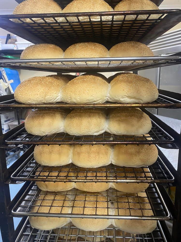 A Bunch Of Hamburger Buns Are Sitting On A Rack In A Bakery β Cedar Park Bakehouse in Taranganba, QLD