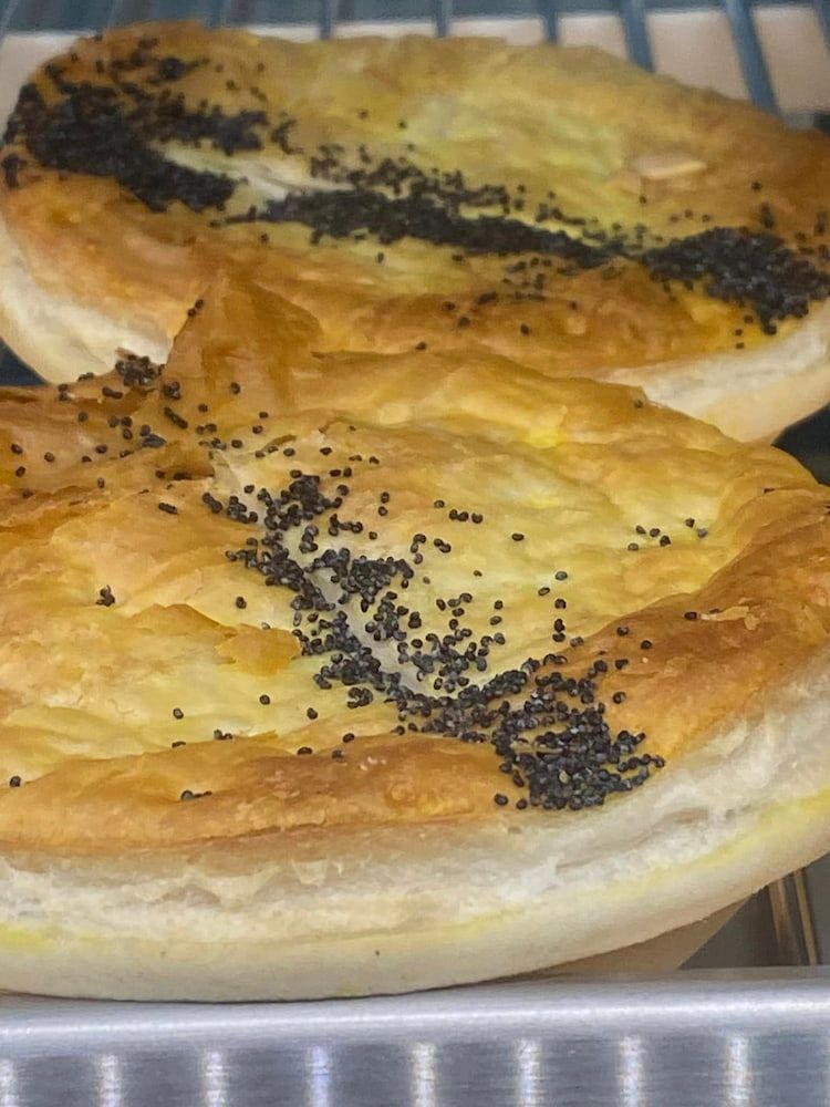 Two Pies Are Sitting On Top Of A Metal Tray On A Shelf — Cedar Park Bakehouse in Taranganba, QLD