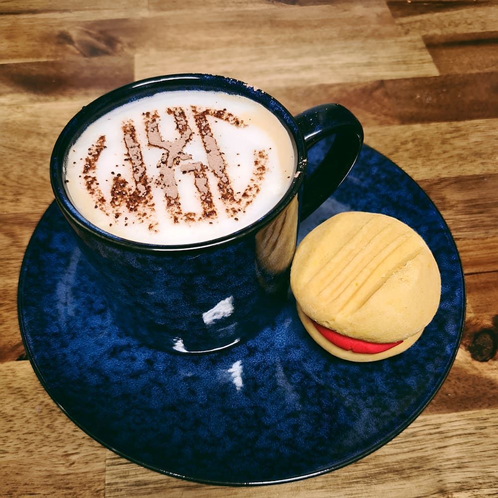 A Cup Of Coffee With The Word Cake Written On It — Cedar Park Bakehouse in Taranganba, QLD