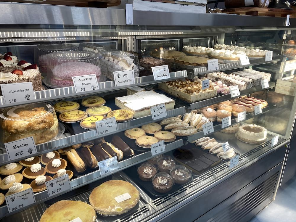 A Display Case Filled With A Variety Of Pastries And Cakes — Cedar Park Bakehouse in Taranganba, QLD