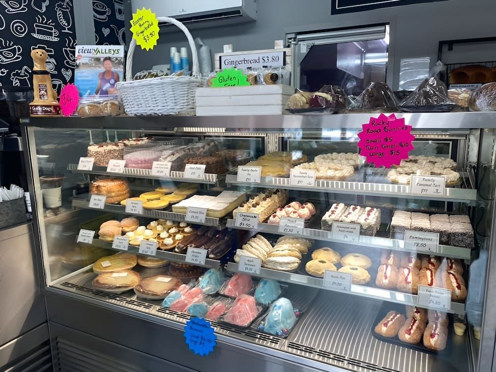 A Display Case Filled With A Variety Of Pastries And Cakes — Cedar Park Bakehouse in Taranganba, QLD