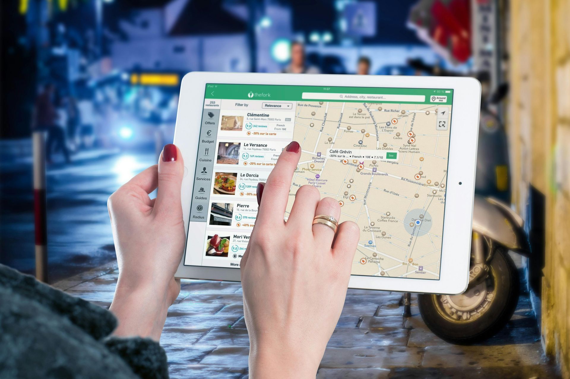 A woman is holding a tablet with a map on it.