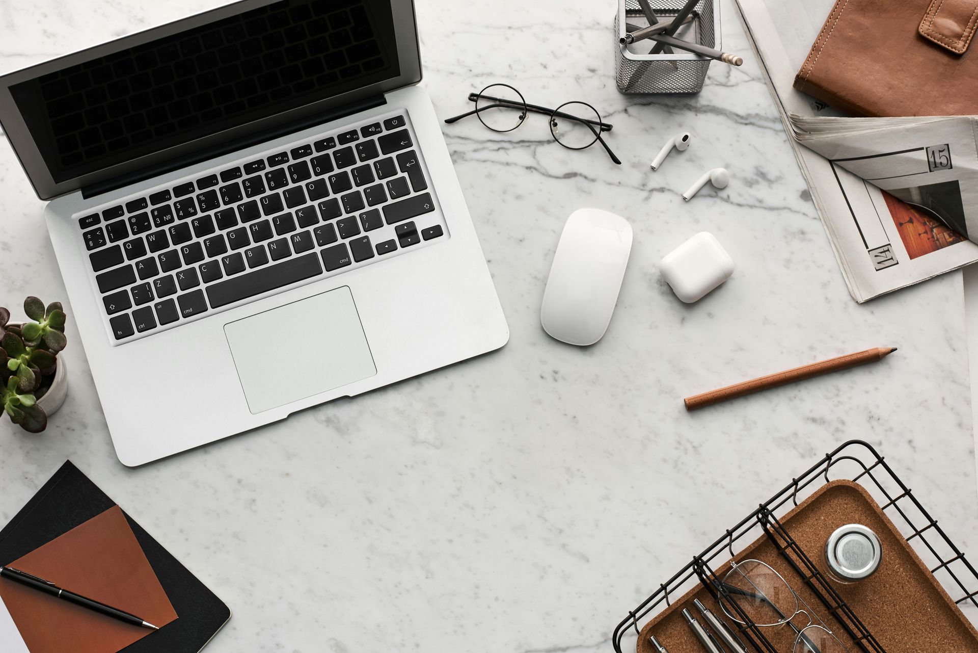 A laptop computer is sitting on a desk next to a mouse and a pencil.