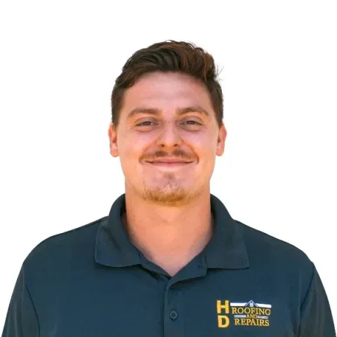 Man wearing a dark blue polo shirt with a company logo, smiling against a white background.
