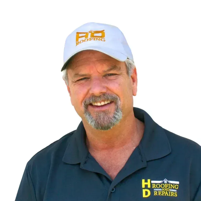 Man wearing a white hat with company logo and a dark blue shirt, smiling.