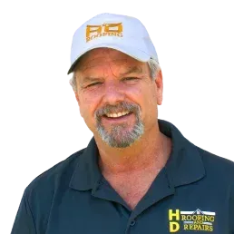 Man wearing a baseball cap with "HD Roofing and Repairs" logo, smiling, yellow background.