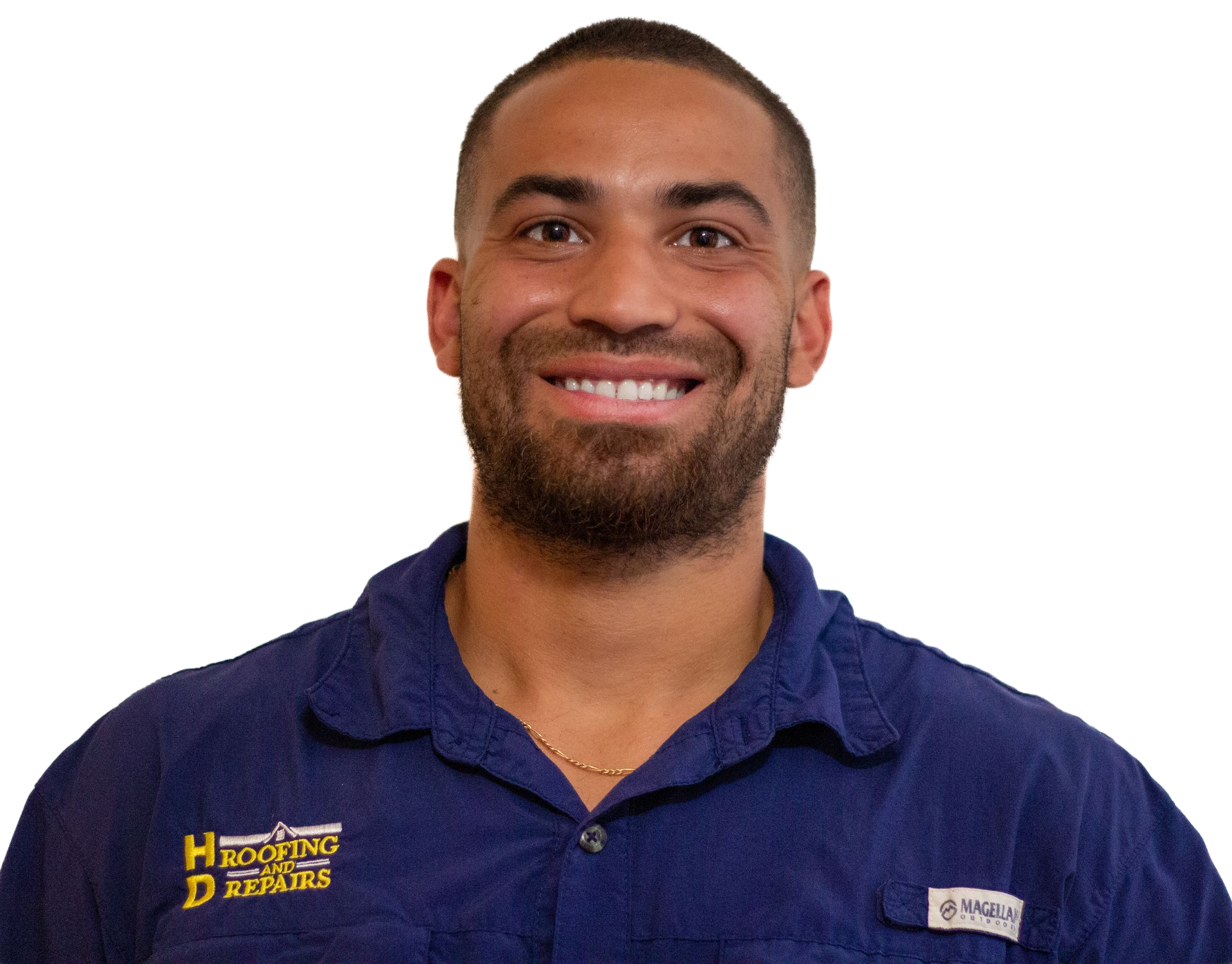Man in blue shirt smiling, wearing a necklace. The shirt has a pocket with logo.