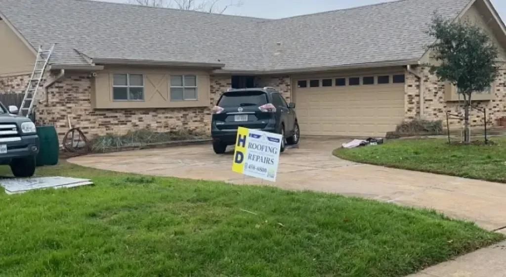 SUV parked in driveway of a house, with a sign in front.