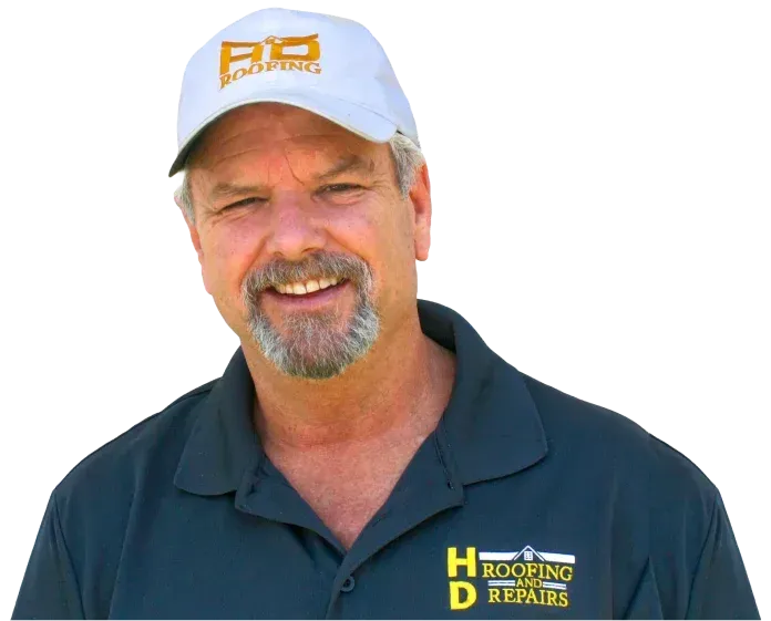 Man wearing a hat and shirt with an HD Roofing logo smiles at the viewer.