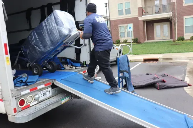 A man is loading a refrigerator into a moving truck.
