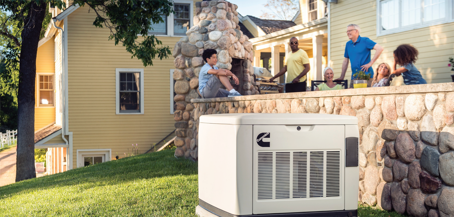 A family is sitting on the porch of a house next to a generator.