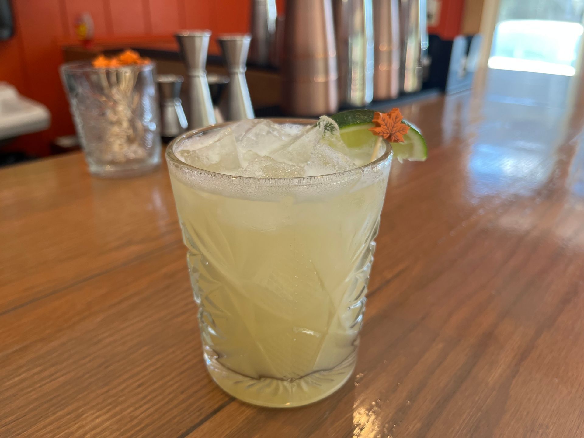 A close up of a drink in a glass on a wooden table.