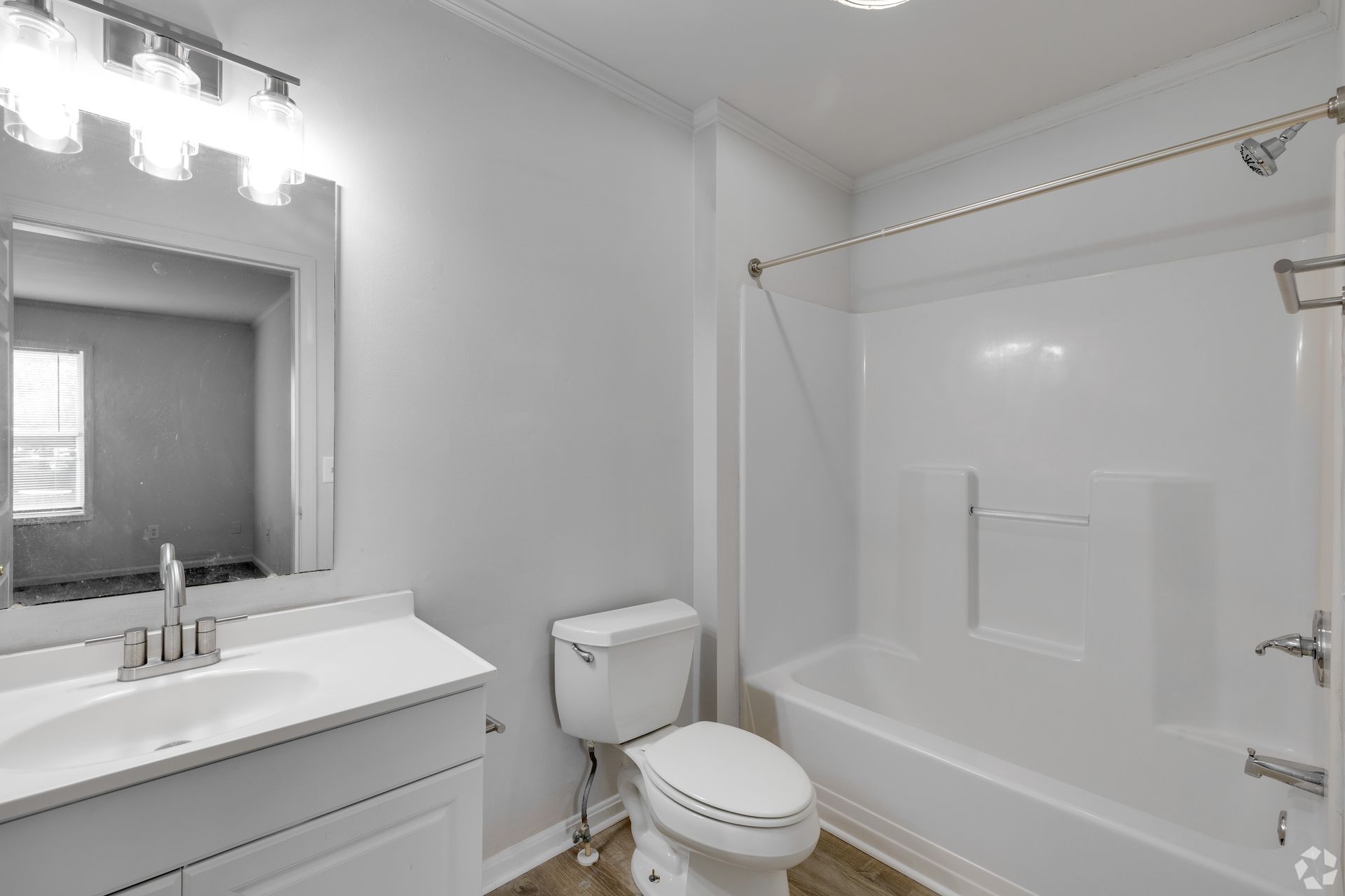 White bathroom with a sink, toilet, and bathtub.