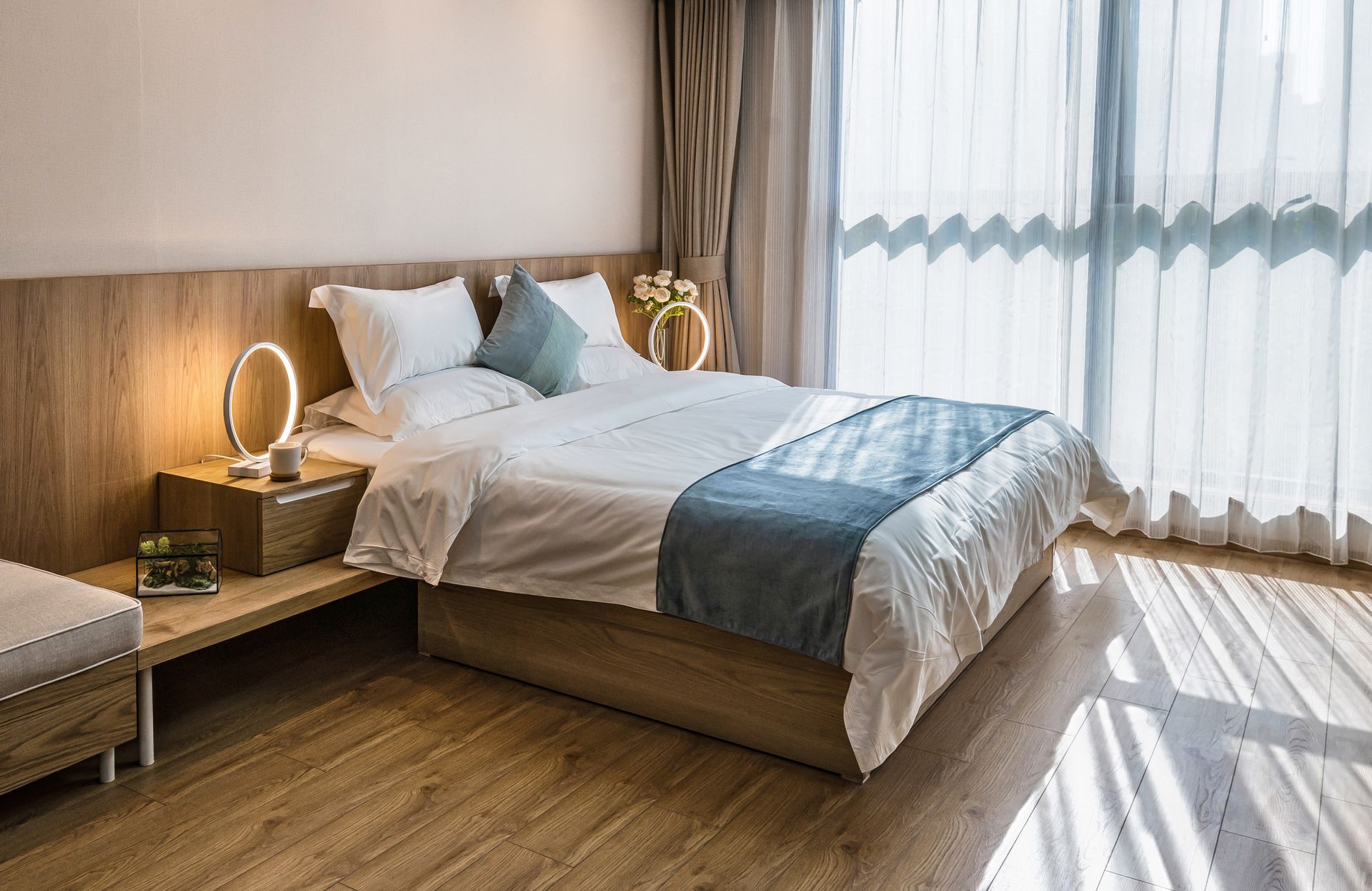 A bedroom with a large bed and a large window.