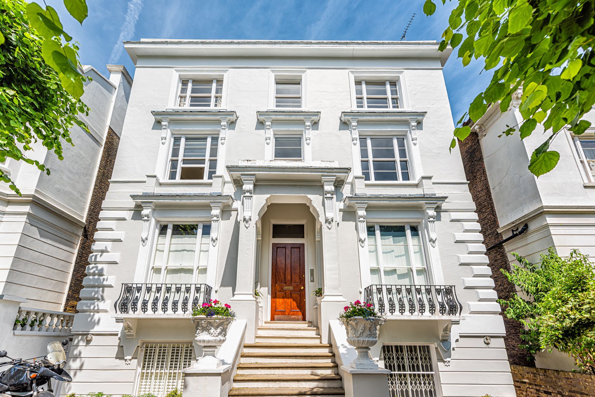 A large white house with a red door and stairs