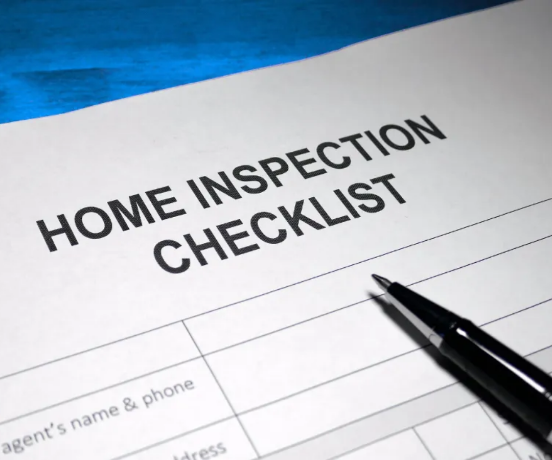 Home inspection checklist form with a pen on a blue surface