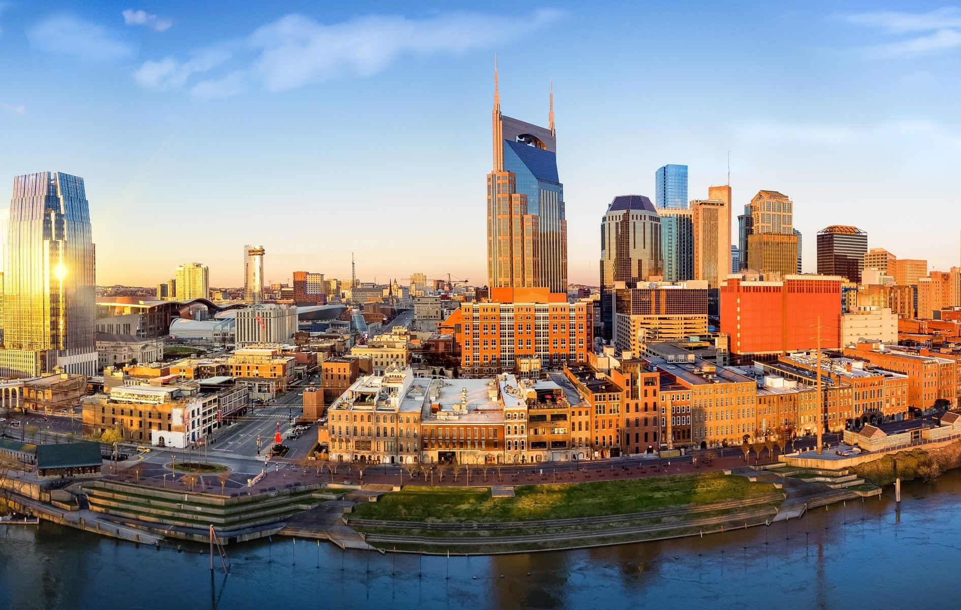 An aerial view of a city skyline with a river in the foreground.