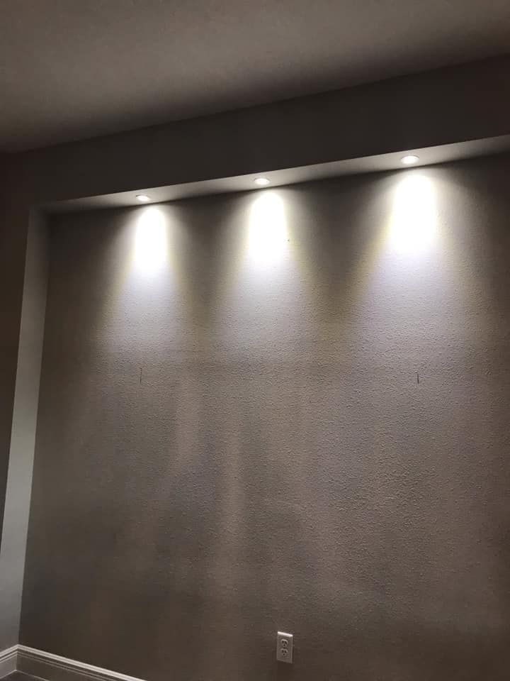 A wall with three lights on it in a room.