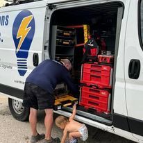 A man and a child are working on a van.